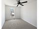A bright bedroom features neutral carpeting, white walls, a ceiling fan, and a single window at 11403 S Grove Dr, Hampton, GA 30228