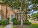 Charming brick townhome featuring a green front door, bay window, and lush landscaping at 11403 S Grove Dr, Hampton, GA 30228