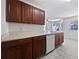 View of kitchen featuring wood cabinets, a white dishwasher and sink, and a white door to the backyard at 11403 S Grove Dr, Hampton, GA 30228