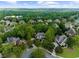 Wide aerial view of neighborhood homes surrounded by trees and a blue sky above at 1416 Elgin Way, Cumming, GA 30041