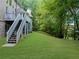 Expansive green backyard with mature trees and access stairs to a second-story deck at 1416 Elgin Way, Cumming, GA 30041