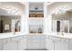 Well-lit bathroom featuring double sinks, vanity cabinets, and a central storage cabinet at 1416 Elgin Way, Cumming, GA 30041