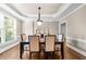 Elegant dining room with tray ceiling, hardwood floors, and a window that lets in natural light at 1416 Elgin Way, Cumming, GA 30041