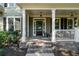 Inviting front porch featuring classic columns, brick steps, and stylish hanging lanterns at 1416 Elgin Way, Cumming, GA 30041