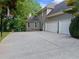 Exterior view of the house featuring a two-car garage and an expansive concrete parking area at 1416 Elgin Way, Cumming, GA 30041