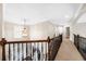 Upstairs hallway features wood railing overlooking the stairs with a decorative pendant light at 1416 Elgin Way, Cumming, GA 30041