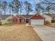 Charming single-story brick home with attached two-car garage and well-kept front yard at 1681 Graystone Dr, Hampton, GA 30228