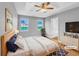 Staged main bedroom with tray ceiling, wood floors, ensuite bathroom, and bright double windows at 1681 Graystone Dr, Hampton, GA 30228