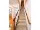 Carpeted staircase with wooden handrails leading to the upper level of the home at 2371 Bellefonte Ave # 61, Lawrenceville, GA 30043