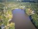 Scenic aerial view of a calm lake surrounded by lush trees with fall foliage and some homes at 427 Picketts Lake Dr, Acworth, GA 30101