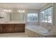 Bright bathroom featuring a large tub and a double sink vanity with modern lighting at 427 Picketts Lake Dr, Acworth, GA 30101