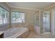 Bright bathroom with a separate glass shower and a large tub near a large window at 427 Picketts Lake Dr, Acworth, GA 30101