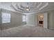 A spacious main bedroom with tray ceiling and ceiling fan, adjacent to the bathroom at 427 Picketts Lake Dr, Acworth, GA 30101