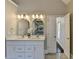 Bathroom with double sink vanity with white marble countertop and lighting, next to doorway at 4634 Meadow Bluff Ln, Suwanee, GA 30024