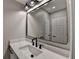 Modern bathroom with a black framed mirror, stylish lighting, and white marble vanity at 4634 Meadow Bluff Ln, Suwanee, GA 30024