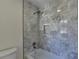 Stylish bathroom featuring a tub with marble tiled walls and a modern shower head at 4634 Meadow Bluff Ln, Suwanee, GA 30024