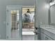 Bathroom with double doors leading to a patio with a ceiling fan, white marble countertops and light gray walls at 4634 Meadow Bluff Ln, Suwanee, GA 30024