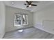 Bright bedroom featuring light wood floors, a ceiling fan, and large windows at 4634 Meadow Bluff Ln, Suwanee, GA 30024