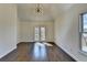 Spacious bedroom featuring hardwood floors, a modern chandelier, and French doors to a covered patio at 4634 Meadow Bluff Ln, Suwanee, GA 30024