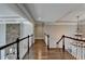 Hallway with hardwood floors, stone accent wall, wooden railing, and decorative chandelier at 4634 Meadow Bluff Ln, Suwanee, GA 30024