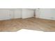 Large basement with light hardwood flooring, white walls, and multiple access doors at 165 Cedarwood Ln, Roswell, GA 30075