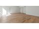Expansive basement with light hardwood flooring, white walls, and multiple doorways at 165 Cedarwood Ln, Roswell, GA 30075