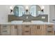 Double sink vanity with dual round mirrors, modern lighting, and attractive wood cabinets create an elegant bathroom space at 165 Cedarwood Ln, Roswell, GA 30075