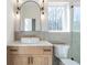 Bathroom featuring an arched mirror, stylish vanity, modern fixtures, and a glass-enclosed shower at 165 Cedarwood Ln, Roswell, GA 30075