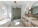 Bright bathroom featuring a standalone tub, glass shower, double vanity with modern fixtures, and stylish lighting at 165 Cedarwood Ln, Roswell, GA 30075