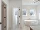 Bright bathroom featuring a standalone tub, stylish finishes, and plentiful natural light from the large windows at 165 Cedarwood Ln, Roswell, GA 30075