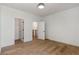 A bright bedroom with hardwood floors, white walls, and two doorways to other rooms at 165 Cedarwood Ln, Roswell, GA 30075