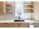 Kitchen sink area with open shelving and natural wood cabinets offers a sleek and functional design at 165 Cedarwood Ln, Roswell, GA 30075