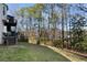 Grassy backyard with multi-level deck and surrounding mature trees at 2447 Tift Nw Ct, Kennesaw, GA 30152