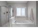 Bathroom featuring a shower, garden tub, and privacy window at 2447 Tift Nw Ct, Kennesaw, GA 30152