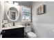 Charming powder room featuring a vanity with a black finish, wainscoting, and stylish decor at 2447 Tift Nw Ct, Kennesaw, GA 30152