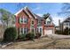 Lovely two-story brick home with an attached garage, manicured shrubs, and an American flag at 2447 Tift Nw Ct, Kennesaw, GA 30152