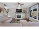 Cozy living room with a fireplace, plush sofa, large windows, and a ceiling fan at 2447 Tift Nw Ct, Kennesaw, GA 30152