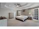 Spacious main bedroom with carpet floors, a ceiling fan, and bedside tables at 2447 Tift Nw Ct, Kennesaw, GA 30152