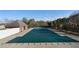 Community pool with protective cover, surrounded by a pool deck and trees at 2447 Tift Nw Ct, Kennesaw, GA 30152