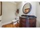 Elegant half bathroom features a dark wood vanity with a black countertop and decorative oval mirror at 2916 Kings Walk Ave, Marietta, GA 30062