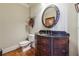 Elegant half bathroom features a dark wood vanity with a black countertop and decorative oval mirror at 2916 Kings Walk Ave, Marietta, GA 30062