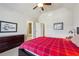 Comfortable bedroom featuring a bed with red plaid cover, ceiling fan, and neutral walls, with ensuite bathroom access at 2916 Kings Walk Ave, Marietta, GA 30062