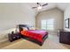 Cozy bedroom featuring a bed with red plaid cover, ceiling fan, and neutral walls, creating a relaxing atmosphere at 2916 Kings Walk Ave, Marietta, GA 30062
