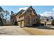 Side view of home featuring a brick and stone facade, a three-car garage and a well-maintained lawn at 2916 Kings Walk Ave, Marietta, GA 30062