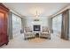 Cozy living room featuring a fireplace, large windows, plush carpet, and two comfortable floral chairs at 2916 Kings Walk Ave, Marietta, GA 30062