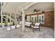 Inviting covered patio with stone floors, ceiling fans, comfortable seating, and brick exterior at 4235 Iron Duke Ct, Peachtree Corners, GA 30097