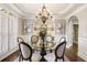 Elegant dining room with hardwood floors, modern chandelier, and white wainscoting at 4235 Iron Duke Ct, Peachtree Corners, GA 30097