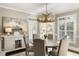 Bright dining room features a round table, antler chandelier, and a large window providing natural light at 4235 Iron Duke Ct, Peachtree Corners, GA 30097