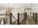 Elegant hallway featuring a chandelier, hardwood floors, and iron railings for a grand entrance at 4235 Iron Duke Ct, Peachtree Corners, GA 30097