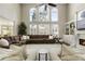 Spacious living room boasts a soaring ceiling, large windows, a cozy fireplace, and a comfortable sectional sofa at 4235 Iron Duke Ct, Peachtree Corners, GA 30097